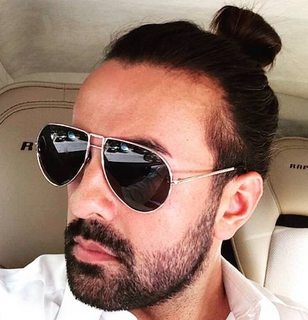 A-picture-of-an-Arab-male-with-a-topknot-hairstyle-and-stubble-wearing-sunglasses-in-his-Ferrari-car.jpg